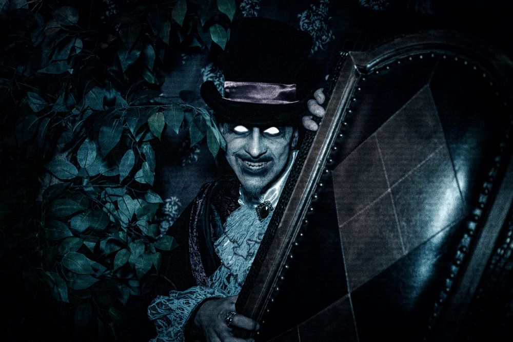 A character with heavy makeup and menacing eyes hides behind a chair.
