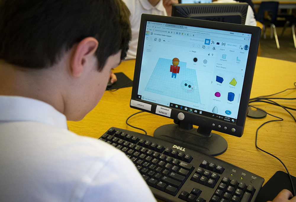 A student at St. John Fisher Catholic School in Portland, Oregon, is pictured in a 2018 photo working on the design of a prosthetic hand for underprivileged children. The head of the Archdiocese of Portland in Oregon has refuted media reports that the archdiocese's recent closure of its Catholic schools office is related to a gender identity theory document published by the archdiocese in January. (OSV News/CNS file, Chaz Muth)