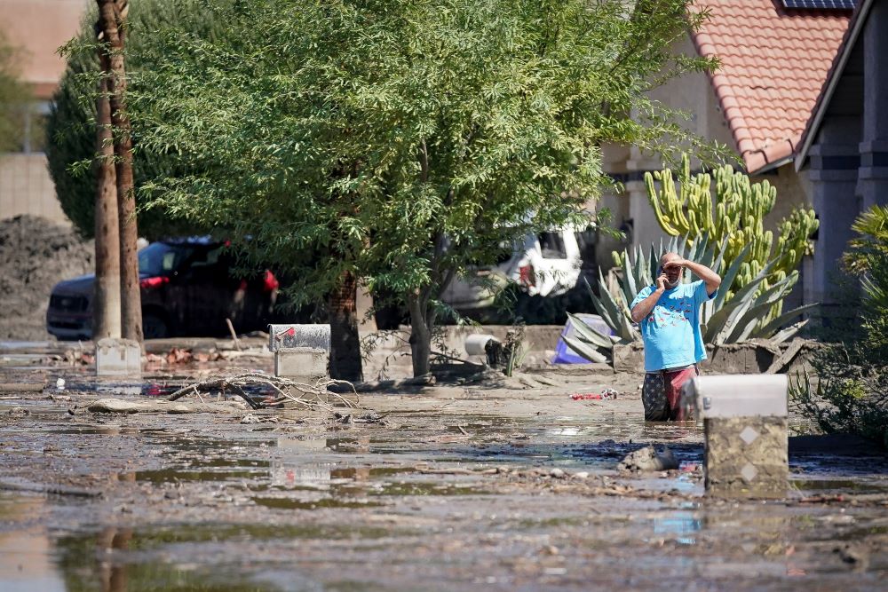 A man stands in mud as he surveys the damage in his front yard in Cathedral City, Calif., Aug. 21, 2023, after Tropical Storm Hilary swept through the area. Hilary, the first tropical storm to hit Southern California in 84 years, flooded roads, toppled trees and forced a rescue by bulldozer of more than a dozen older residents trapped by mud in an assisted-living facility as it marched northward, prompting flood watches and warnings in half a dozen states. (OSV News/Reuters/Bryan Woolston)