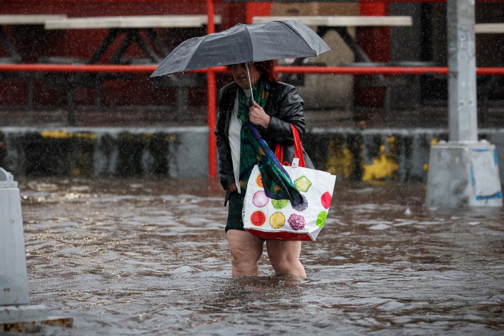 A woman walks through rain and flood waters in the Brooklyn borough of New York City Sept. 29, 2023, as the remnants of Tropical Storm Ophelia brought flooding across the mid-Atlantic and Northeast. (OSV News/Reuters/Brendan McDermid)