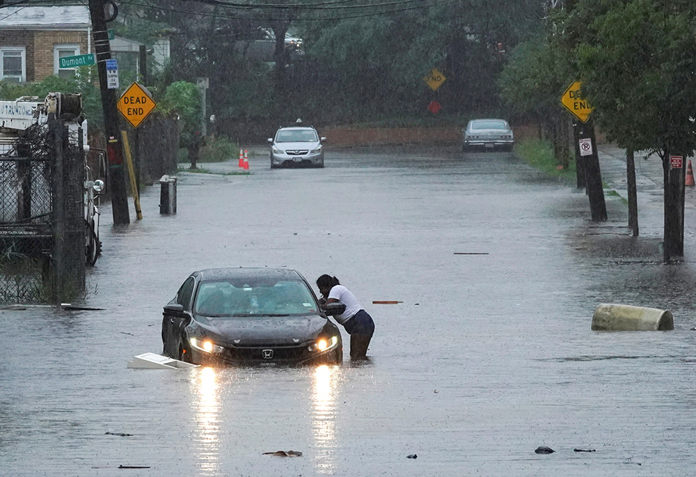A passenger speaks with the driver of a vehicle stuck in waters from flash flooding in New York City Sept. 29, as remnants of Tropical Storm Ophelia brought flash flooding across the mid-Atlantic and Northeast. "The world in which we live is collapsing and may be nearing the breaking point," warns Francis in Laudate Deum ("Praise God"). (OSV News/Reuters/Bing Guan)