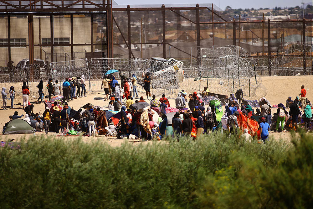 Migrants, mostly from Venezuela, are seen from Ciudad Juárez, Mexico, as they gather near the U.S. border wall Sept. 24, after crossing the Rio Grande with the intention of turning themselves in to U.S. Border Patrol agents to request asylum. (OSV News/Reuters/Jose Luis Gonzalez)