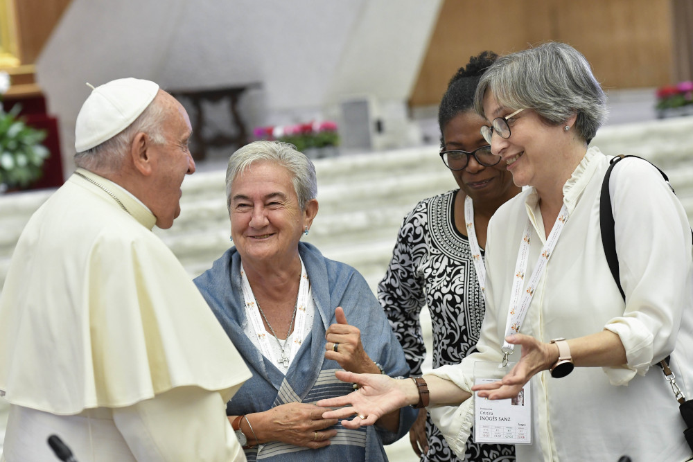 Pope Francis shares a laugh with some of the women members of the assembly of the Synod of Bishops, including Spanish theologian Cristina Inogés Sanz, left, at the assembly's session Oct. 6, 2023, in the Paul VI Audience Hall at the Vatican. (CNS photo/Vatican Media)