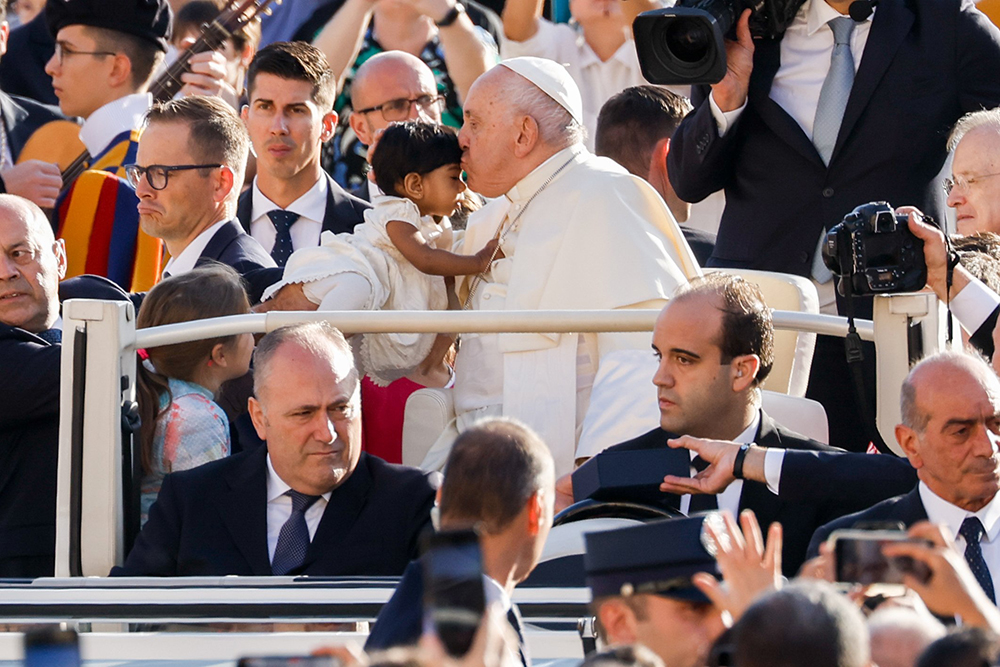 Pope Francis greets a child as he rides in the popemobile around St. Peter’s Square at the Vatican before his weekly general audience Oct. 11. (CNS/Lola Gomez)