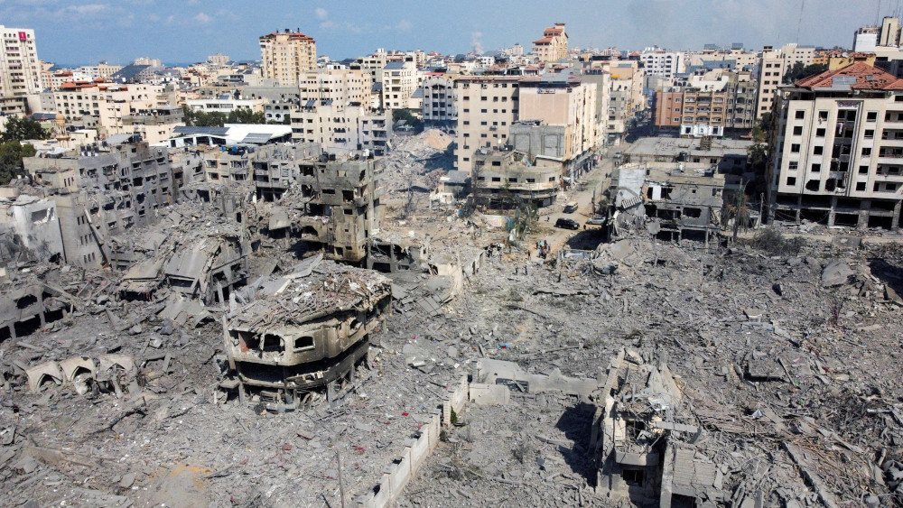 Rubble surrounds the remains of burned out concrete buildings which are seen from an aerial photograph