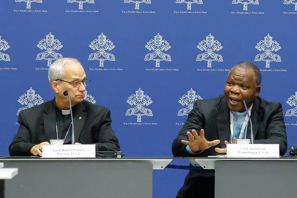 Cardinal Dieudonné Nzapalainga of Bangui, Central African Republic, speaks during a briefing about the assembly of the Synod of Bishops as Cardinal Robert Prevost, prefect of the Dicastery for Bishops, listens at the Vatican Oct. 25. (CNS/Lola Gomez)