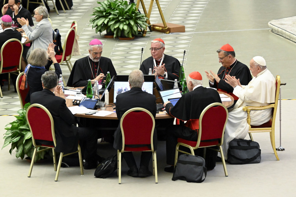 Pope Francis and leaders of the assembly of the Synod of Bishops applaud at the conclusion of the gathering's last working session Oct. 28, in the Paul VI Hall at the Vatican. (CNS/Vatican Media)