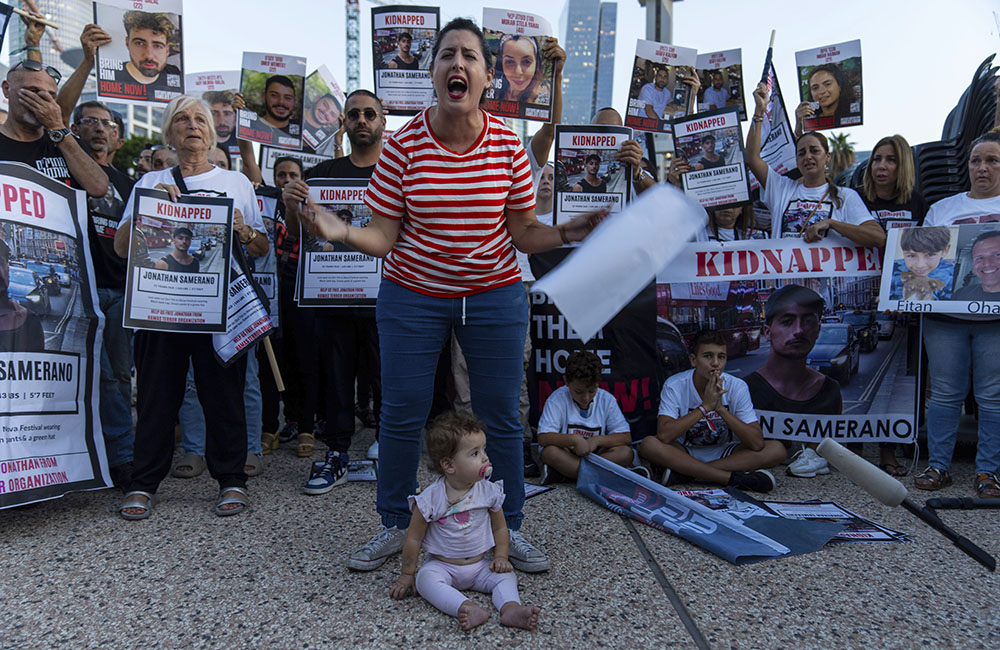 Relatives of people kidnapped by Hamas militants hold the pictures of their loved ones during a protest calling for their return, in Tel Aviv, Israel, Oct. 26. (AP/Ohad Zwigenberg)