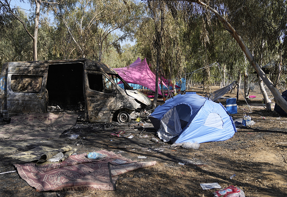 Tents, debris and a burned out van are scattered about the site of a music festival near the border with the Gaza Strip in southern Israel on Oct. 12. At least 260 Israeli festival-goers were killed during the attack by Hamas gunmen on Oct. 7. (AP/Ohad Zwigenberg)