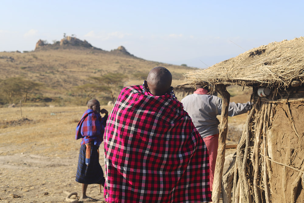 A Maasai woman carrying her baby stands outside her hut in Ngorongoro conservation area in northern Tanzania. The Tanzanian government is evicting the Maasai from their ancestral land, a situation that is significantly affecting women and children. (GSR photo/Doreen Ajiambo)