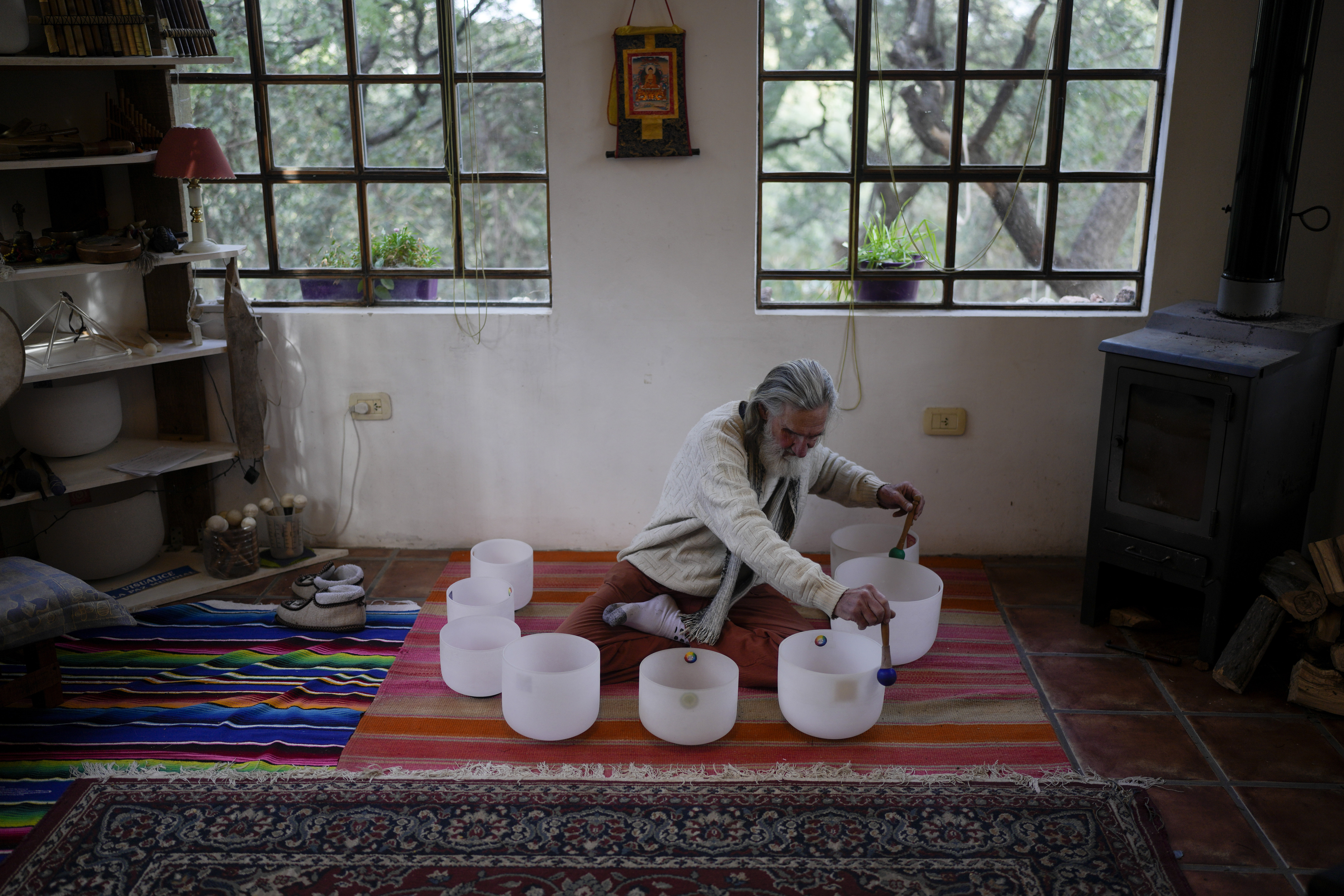 Daniel Brower plays crystal bowls at his home in Capilla del Monte, Cordoba, Argentina, July 18. Brower renounced his Christian upbringing and now looks for his spirituality through music and nature. (AP/Natacha Pisarenko)