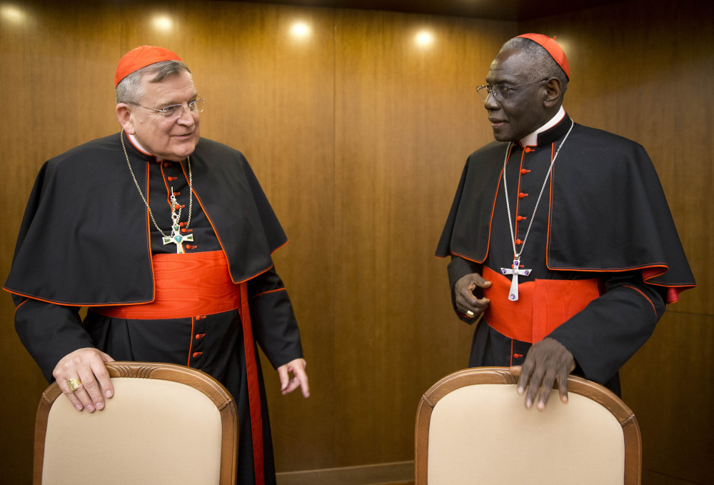 Cardinal Raymond Leo Burke, left, talks with Cardinal Robert Sarah, then-prefect of the Congregation for Divine Worship and the Discipline of the Sacraments, in October 2015. (AP Photo/Andrew Medichini, File)