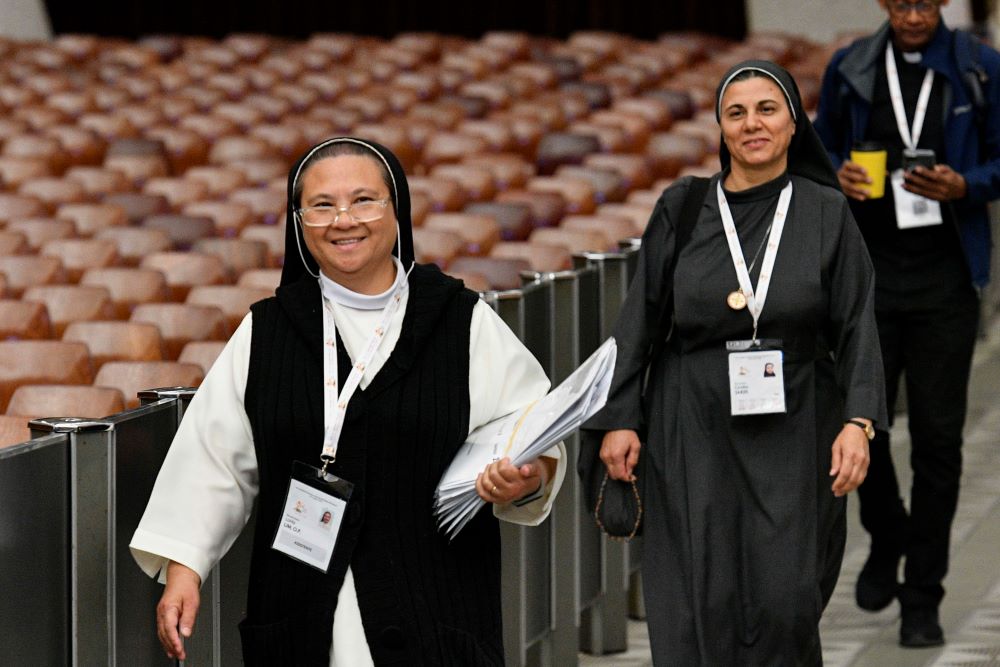 Sr. Loida Lim, a member of the Missionaries of St. Dominic, and Sr. Caroline Saheed Jarjis, a member of the Daughters of the Sacred Heart of Jesus, arrive for the afternoon session of the assembly of the Synod of Bishops in the Paul VI Audience Hall at the Vatican Oct. 13. (CNS/Vatican Media)