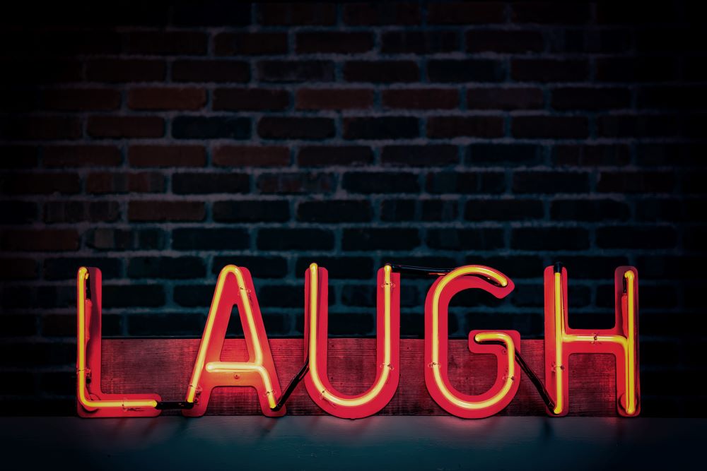 Red neon light says "LAUGH."