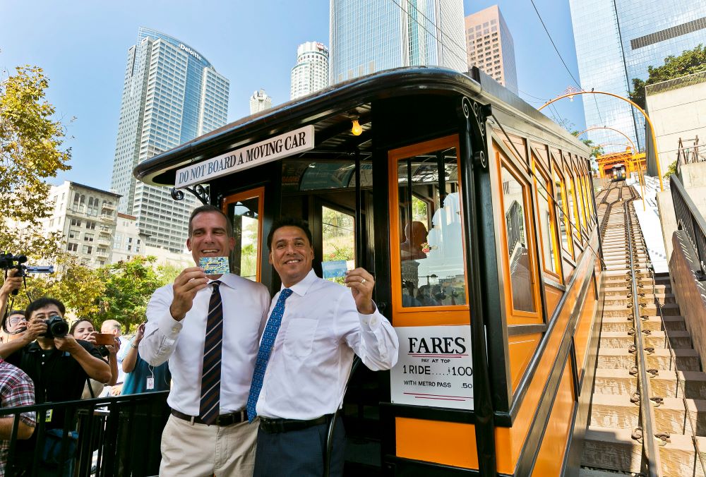 José Huizar, right, then a Los Angeles council member, is pictured with L.A. Mayor Eric Garcetti showing their Metro cards as they ride the Angels Flight Aug. 31, 2017.