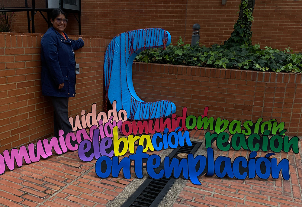 A woman poses with a display of seven words starting with the letter C on the campus of La Salle University Nov. 24 in Bogotá, Colombia. The president of CLAR, which organized the IV Latin American and Caribbean Congress of Religious Life Nov. 24-26, said she hoped that practicing care, contemplation, communication, celebration, creation, community and compassion would "mold our hearts in a new way," referring to those in consecrated life. (GSR photo/Rhina Guidos)
