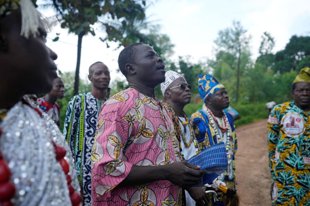 A voodoo priest calls on the spirit outside the Oro sacred forest in Adjarra, Benin, on Wednesday, Oct. 4, 2023. As the government grapples with preserving the forests while developing the country, Voodoo worshippers worry the loss of its spaces could have far reaching effects. (AP/Sunday Alamba)