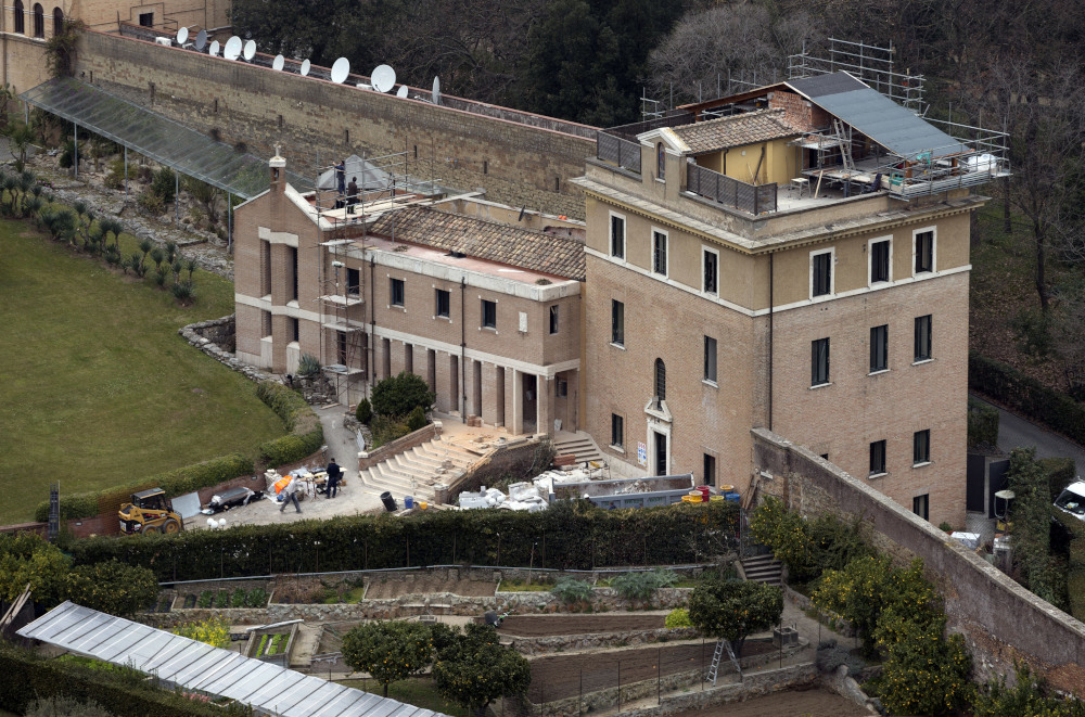 An aerial view of a building with a short tower and a shorter wing. It appears there is construction or renovation in progress.