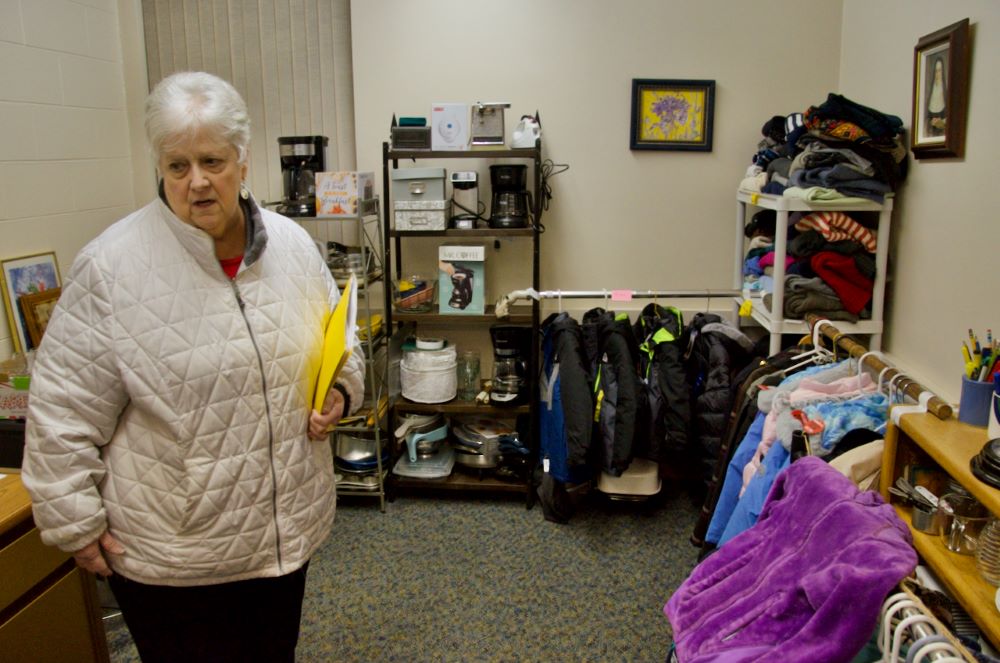 Carol Conway, asociada de la comunidad de las Hermanas de la Misericordia, el 13 de diciembre de 2023, muestra una de las salas llenas de donaciones donde los solicitantes de asilo pueden conseguir muebles, ropa, pequeños electrodomésticos y enseres domésticos para sus apartamentos. (Foto: GSR/Dan Stockman) 