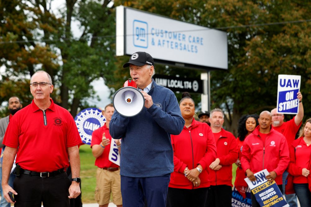 U.S. President Joe Biden speaks next to Shawn Fain, president of the United Auto Workers, as he joins striking UAW members on the picket line outside the GM's Willow Run Distribution Center in Belleville, Michigan, Sept. 26. Biden became the first known sitting U.S. president to join a labor strike. (OSV News/Reuters/Evelyn Hockstein)