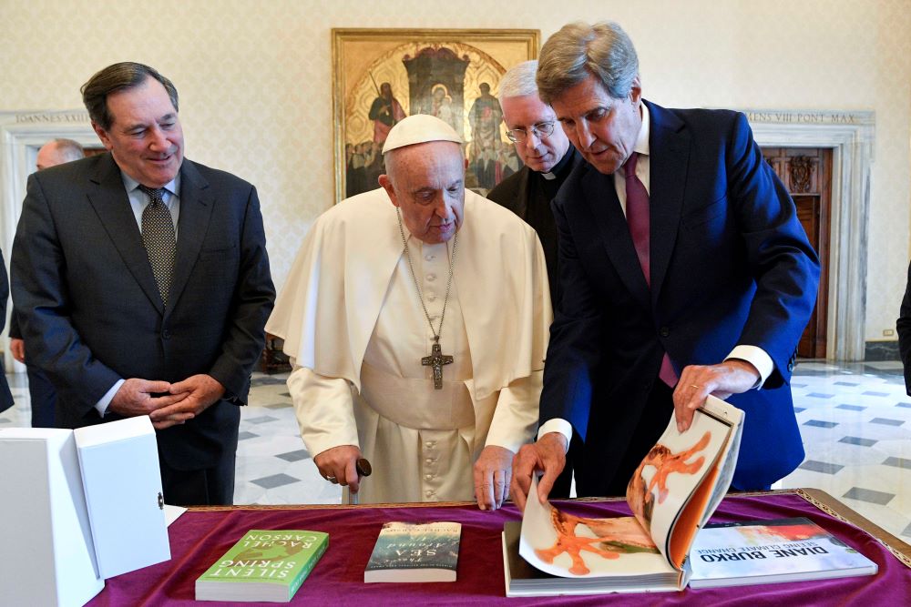Pope Francis looks at a gift offered by John Kerry,