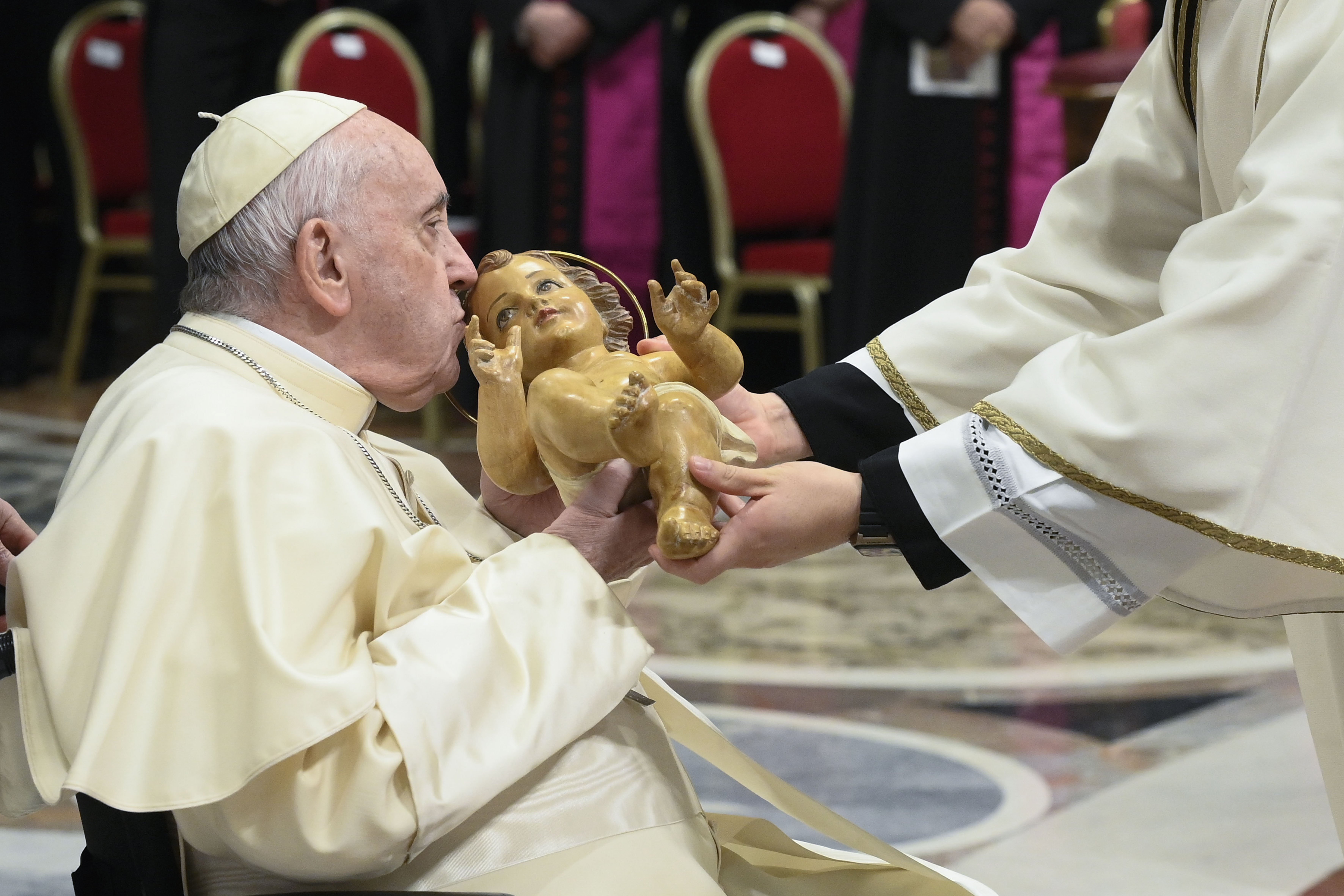 Pope Francis kisses a figurine of the baby Jesus during Christmas Eve Mass in St. Peter's Basilica at the Vatican Dec. 24, 2022. (CNS photo/Vatican Media)