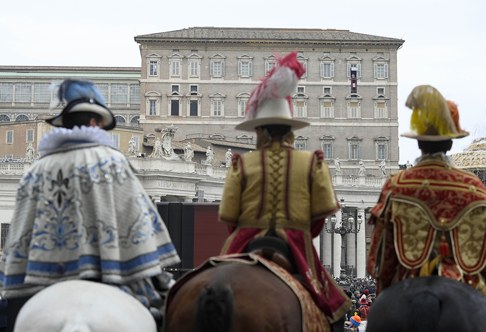 Participants in a parade for the feast of the Epiphany attend Pope Francis' recitation of the Angelus from the window of his studio overlooking St. Peter's Square Jan. 6, 2023, at the Vatican. (CNS/Vatican Media)