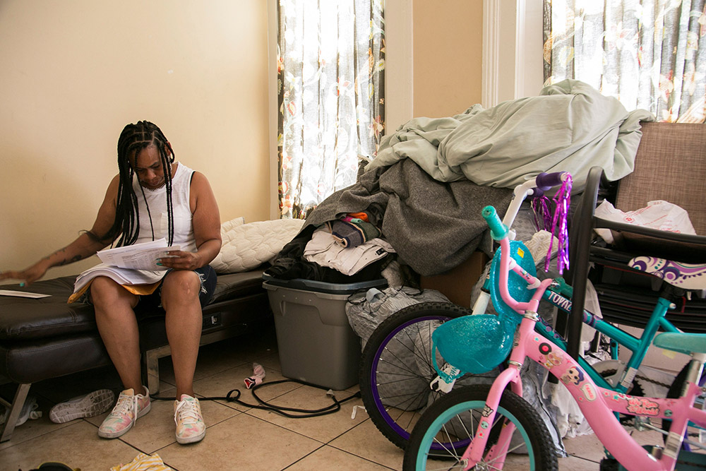 Chaunda Lee, a single mother of eight who has five children living with her, reads mail she received regarding her food stamp aid, in Louisville, Kentucky, Aug. 19, 2021. (OSV News/Reuters/Amira Karaoud)