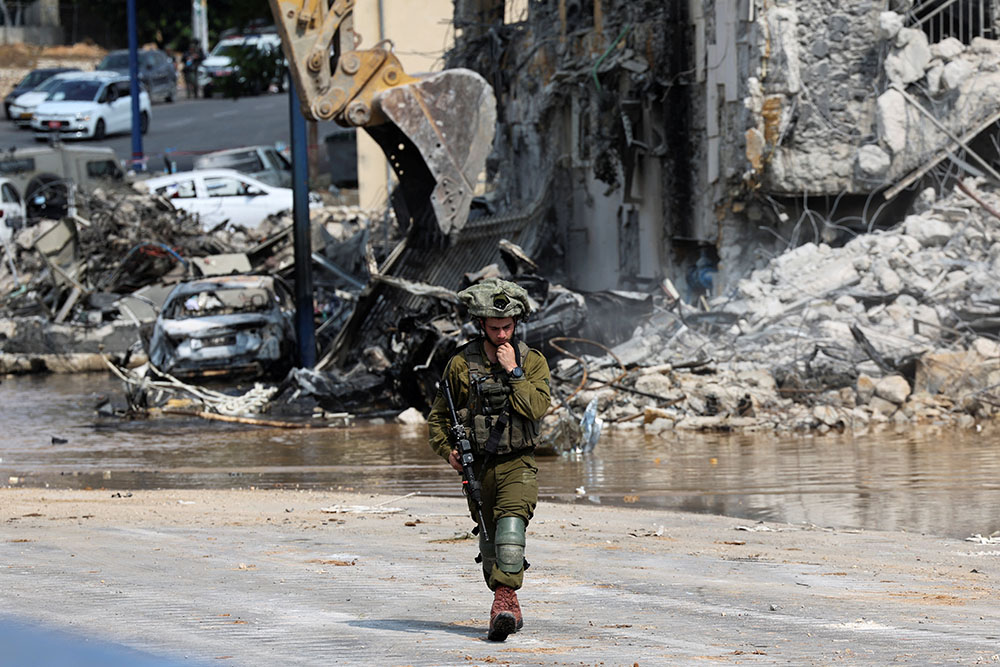 An Israeli soldier patrols near a police station in Sderot, Israel, Oct. 8. The station was destroyed following a mass infiltration by Hamas militants from the Gaza Strip. (OSV News/Reuters/Ronen Zvulun)