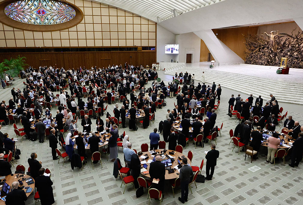 Members of the assembly of the Synod of Bishops pray with Pope Francis before a working session in the Vatican's Paul VI Audience Hall Oct. 16. (CNS/Lola Gomez)