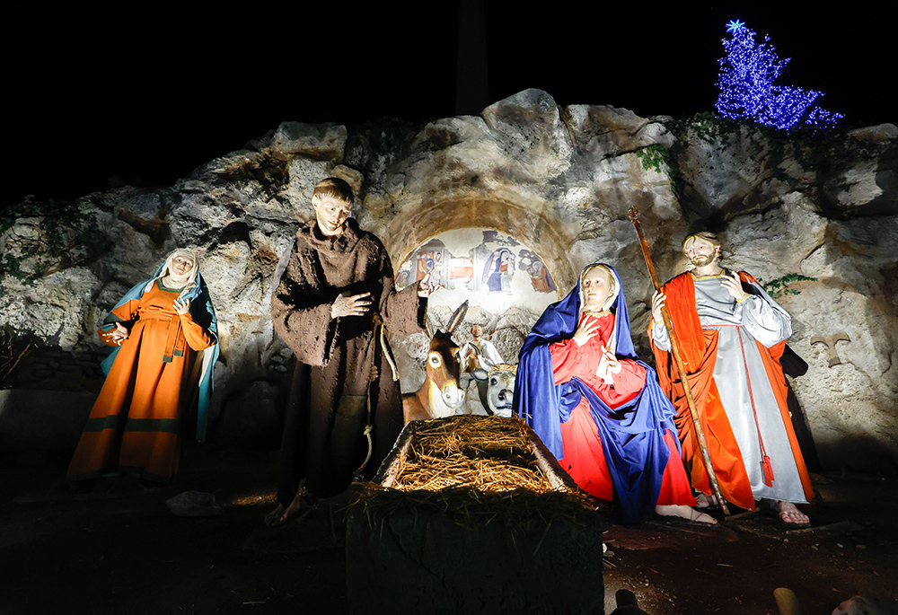 The Nativity scene is revealed and the Christmas tree is lit in St. Peter’s Square Dec. 9 at the Vatican. The crèche is a reproduction of the scene in Greccio, Italy, where St. Francis of Assisi staged the first Nativity scene in 1223. The baby Jesus will be placed in the manger Dec. 24. (CNS/Lola Gomez)