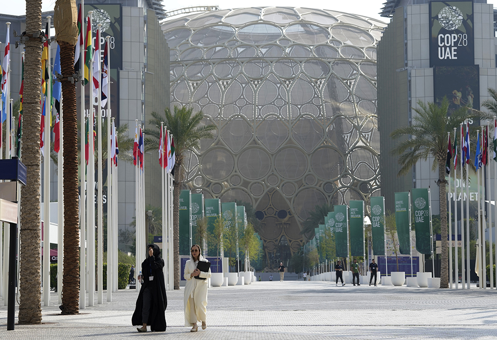 People walk through the COP28 U.N. climate summit Dec. 13 in Dubai, United Arab Emirates. (AP photo/Peter Dejong)