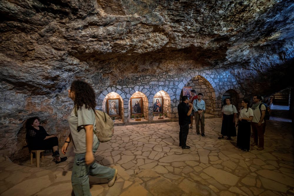 Lebanese priest Hani Tawk, center, gives French tourists a tour of the Saint Elisha monastery, located in the Kadisha Valley, a holy site by Lebanon's Christians, in the northeast mountain town of Bcharre, Lebanon, Saturday, July 22, 2023. (AP/Hassan Ammar)