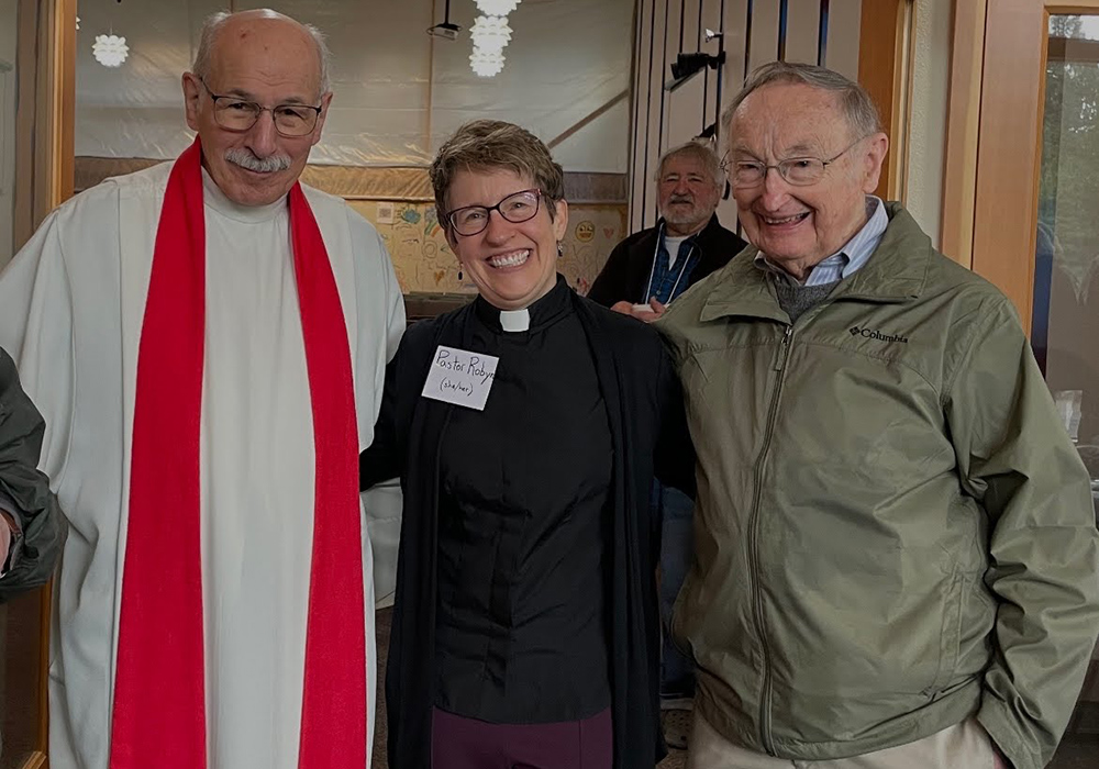 Frs. Jack Mosbrucker and Neil Moore pose with Lutheran Pastor Robyn Hartwig in the foyer of Spirit of Grace in a 2023 photo. (Courtesy of Spirit of Grace) 