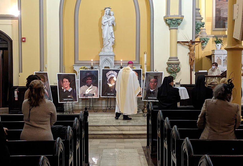 Auxiliary Bishop Bruce Lewandowski of Baltimore censes portraits of the first six African American Catholics on the path to sainthood, performed during an All Saints' Day Mass at St. Ann Catholic Church Nov. 1, 2021, in Baltimore. (Nate Tinner-Williams)