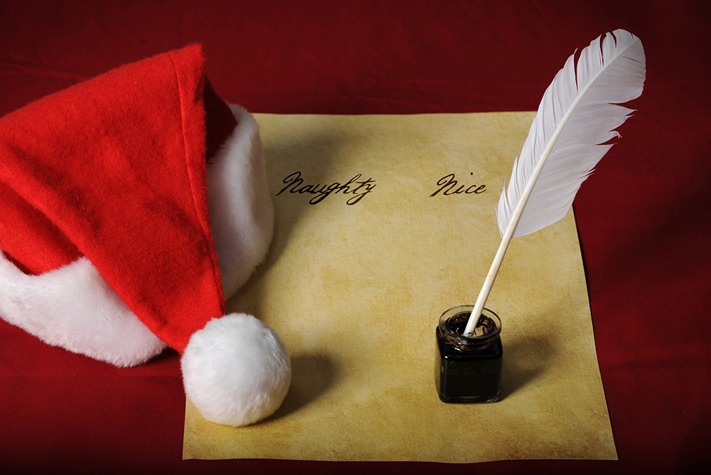 Naughty and nice list with a santa hat and an inkwell with quill (Dreamstime/R. Gino Santa Maria/Shutterfree, Llc)