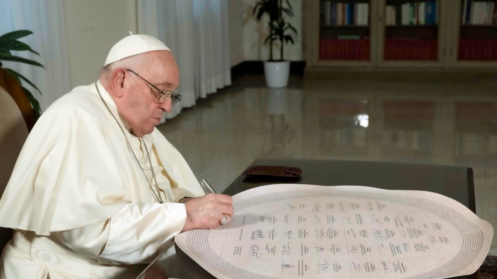 Pope Francis signs the Interfaith Statement on Climate Change in his Vatican residence Dec. 3. 