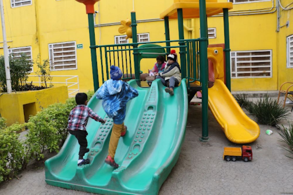 Migrant children play at an outdoor playground at Casanicolás in Guadalupe, Mexico.