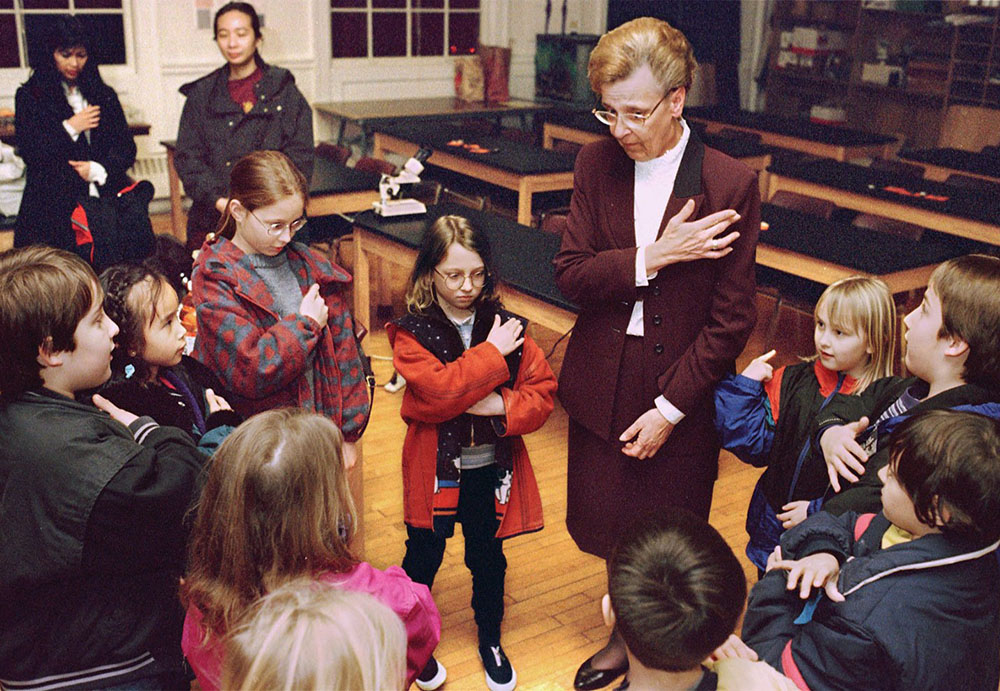 Mary Jo Tully prays with children in her religious education class at the Cathedral of the Immaculate Conception in Portland, Oregon, in 1998. (CNS/Denise Hogan)