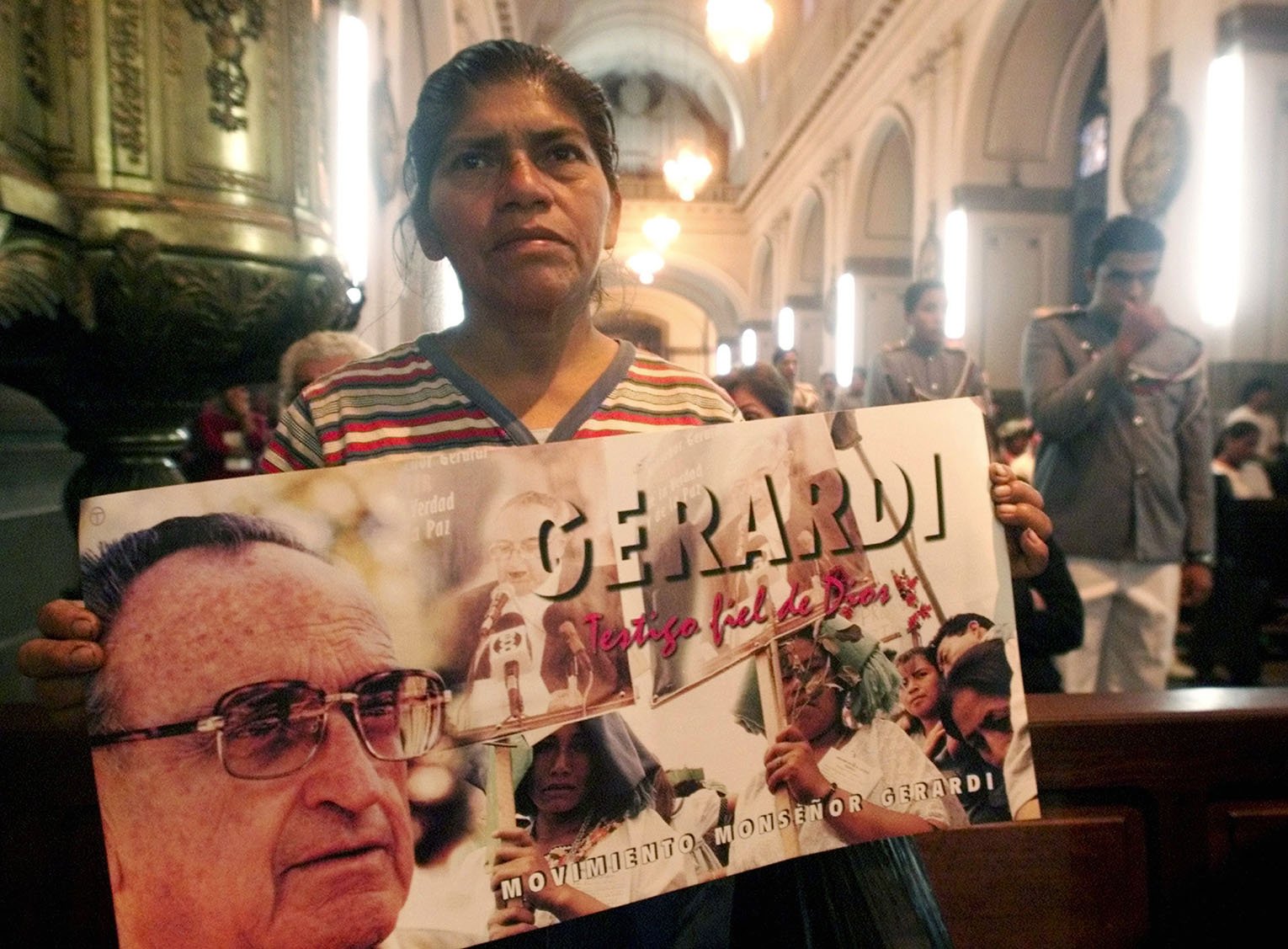 A Guatemalan woman holds a poster honoring slain Auxiliary Bishop Juan Gerardi Conedera April 26, 2002, in the Guatemala City cathedral. 