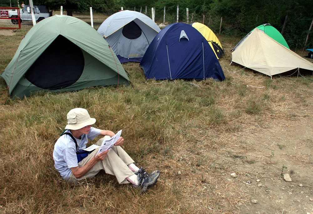 Sacred Heart Sr. Anne Montgomery, a member of the Christian Peacemaker Team, reads outside the "Witness Against Torture" camp at the military zone boundary near the U.S. detention facility in Guantanamo Bay, Cuba, Dec. 13, 2005. (CNS/Reuters)