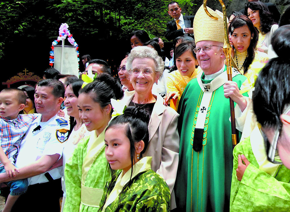 Mary Jo Tully poses with Archbishop John Vlazny and Vietnamese Catholics following a Mass in Portland, Oregon, in 2011. (CNS/Courtesy of Catholic Sentinel)