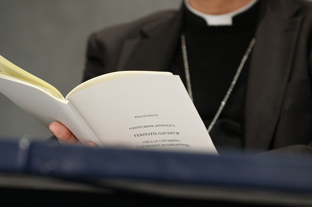 Cardinal Giuseppe Versaldi, prefect of the Congregation for Catholic Education, holds a copy of Pope Francis' apostolic constitution, "Veritatis Gaudium" (The Joy of Truth), during a news conference at the Vatican Jan. 29, 2018. (CNS/Paul Haring)