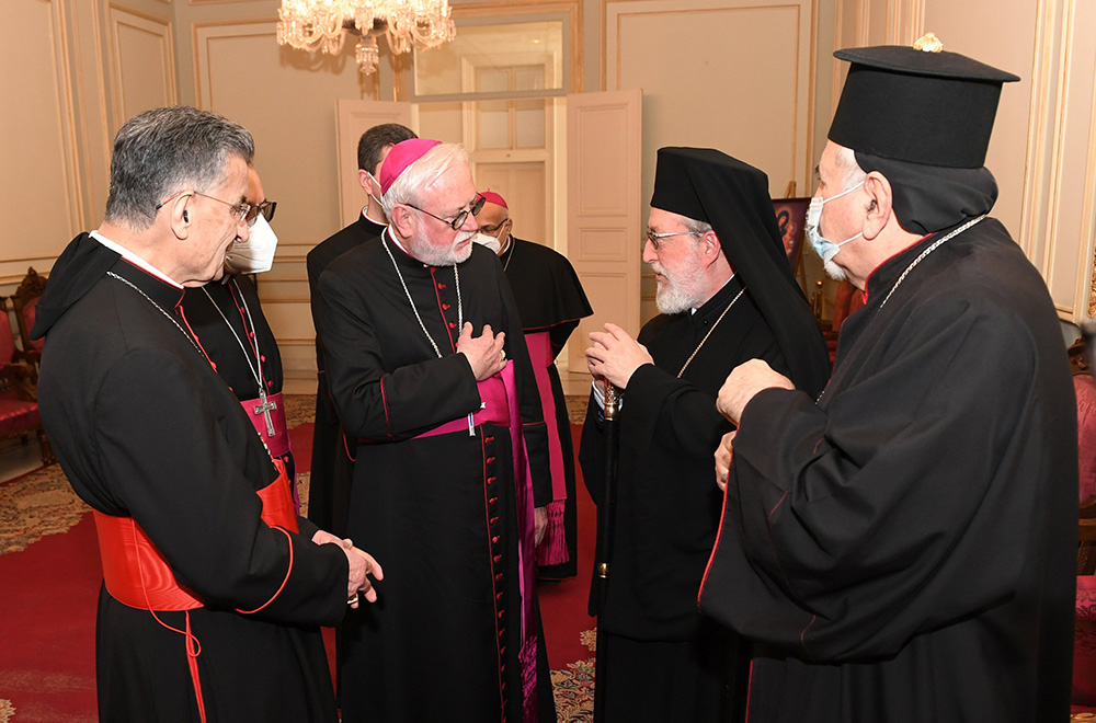 Archbishop Paul Gallagher, Vatican foreign minister, center, speaks with Metropolitan Elias Kfoury, representing Greek Orthodox Patriarch John X, Feb. 2, 2022, as they attend the monthly meeting of the Maronite Catholic bishops at Bkerke, the Maronite patriarchate, near Beirut. At left is Cardinal Bechara Rai, Maronite Catholic patriarch. (CNS/Mychel Akl for Maronite patriarchate)