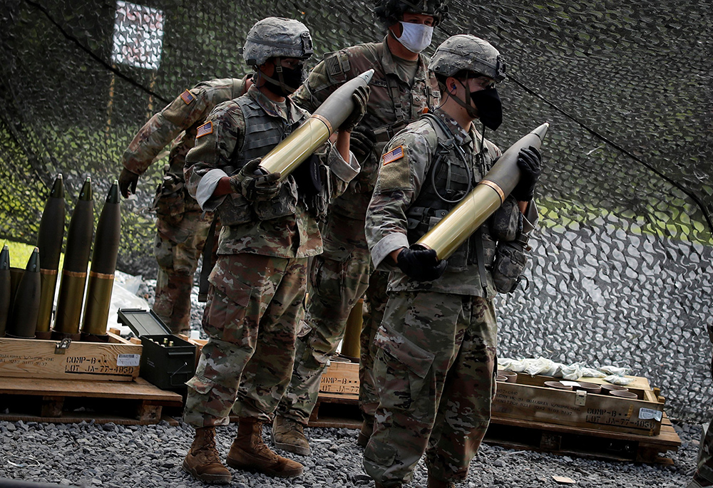 U.S. Military Academy cadets wait to load live 105 mm shells into an M119 105 mm Howitzer artillery weapon during tactical and physical training activities Aug. 7, 2020, at West Point, New York. U.S. bishops have signed a letter calling for the U.S. to cut military spending and instead invest in ending poverty. (CNS/Reuters/Mike Segar)