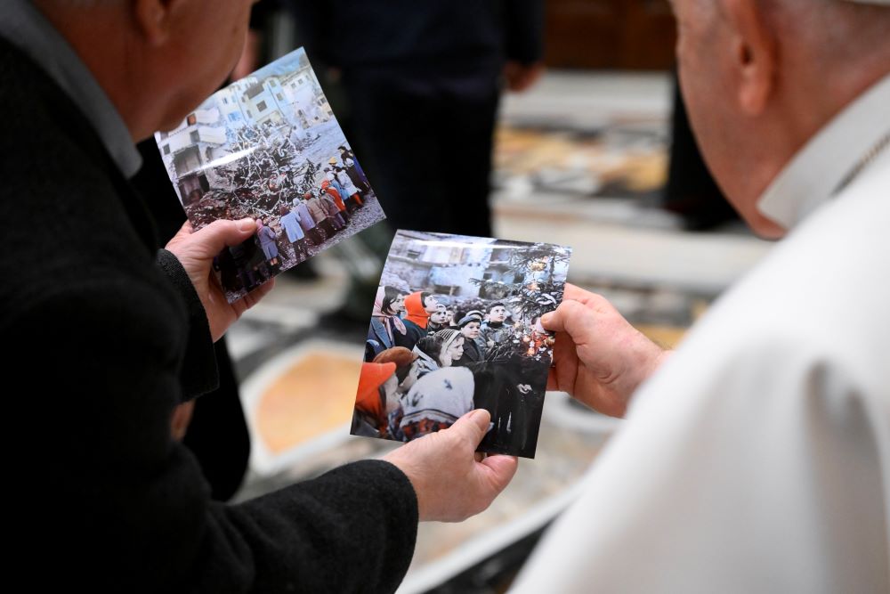 Pope Francis looks at photos of the aftermath of a massive landslide in October 1963 that killed 1,910 people in northern Italy during an audience with pilgrims from the Diocese of Belluno-Feltre and from the association "Vajont: The Future of Memory," and local government officials in the Apostolic Palace at the Vatican Jan. 19, 2024. (CNS photo/Vatican Media)