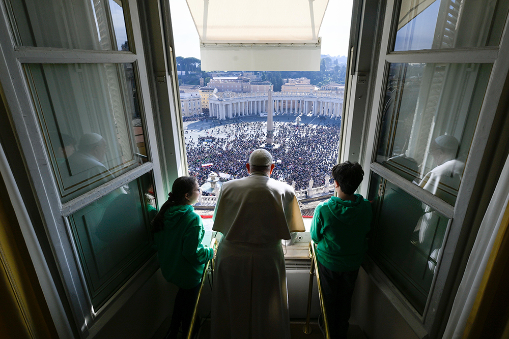 Pope Francis and young people associated with Catholic Action, a lay apostolate, join the pope as he leads the Angelus from his studio overlooking St. Peter's Square at the Vatican Jan. 28, 2024. (CNS/Vatican Media)