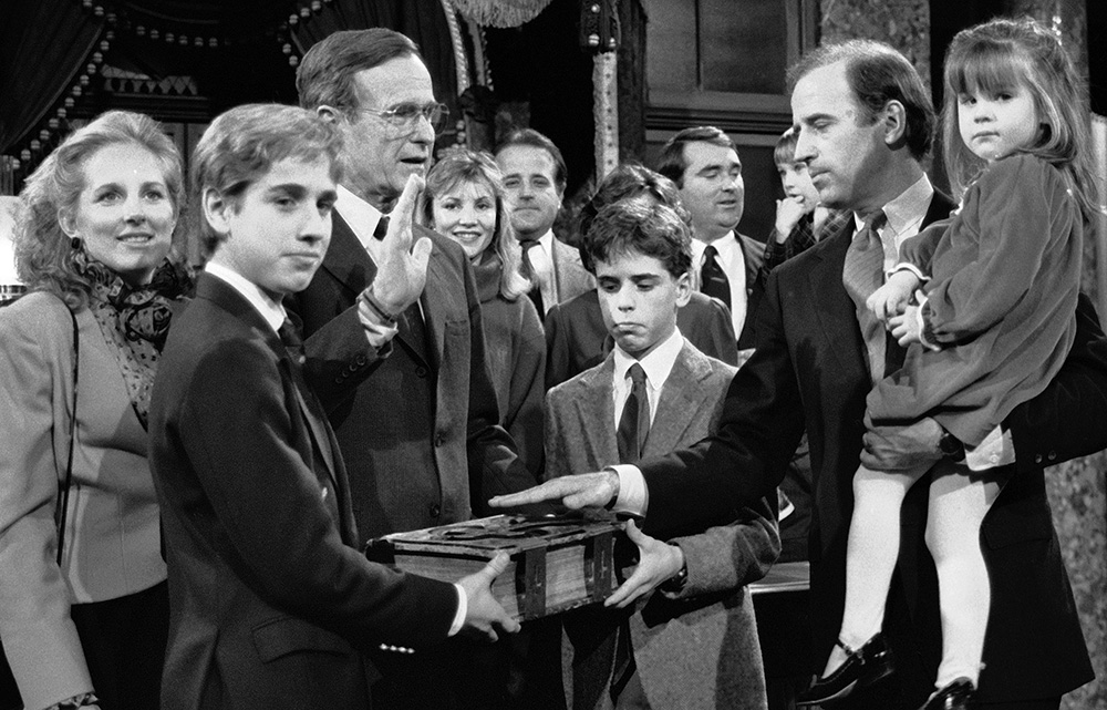 On  Jan. 3, 1985, then-Sen. Joe Biden holds his daughter Ashley while taking a reenacted oath of office from Vice President George Bush during a ceremony on Capitol Hill in Washington. His wife, Jill, looks on and his sons, Beau (foreground) and Hunter, hold the Bible. (AP Photo/Lana Harris)