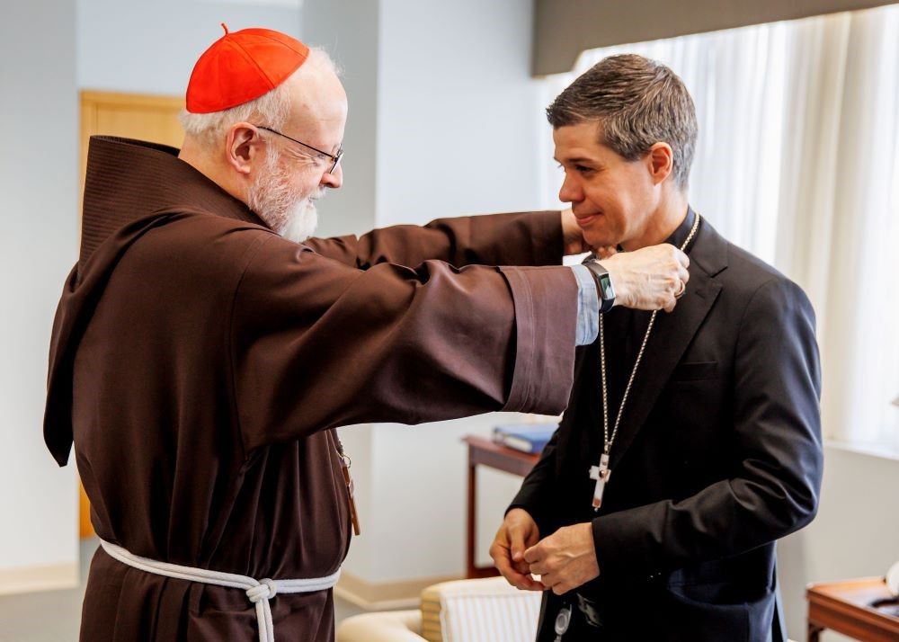 Cardinal Seán O'Malley of Boston gives Bishop-designate Cristiano Barbosa his pectoral cross at the Archdiocese of Boston's pastoral center in Braintree, Mass., on Dec. 9.