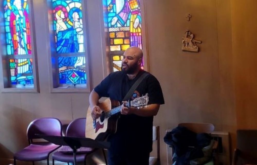 Jon Martin, coordinator for residents in the transformed convent at St. John Vianney Parish, leads music in the chapel.